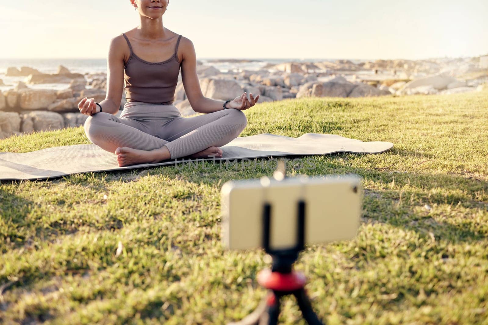 Yoga, meditation and live streaming woman in nature on smartphone for peace, healing and mindfulness content creation on social media. Influencer or fitness content creator meditate outdoor on video.