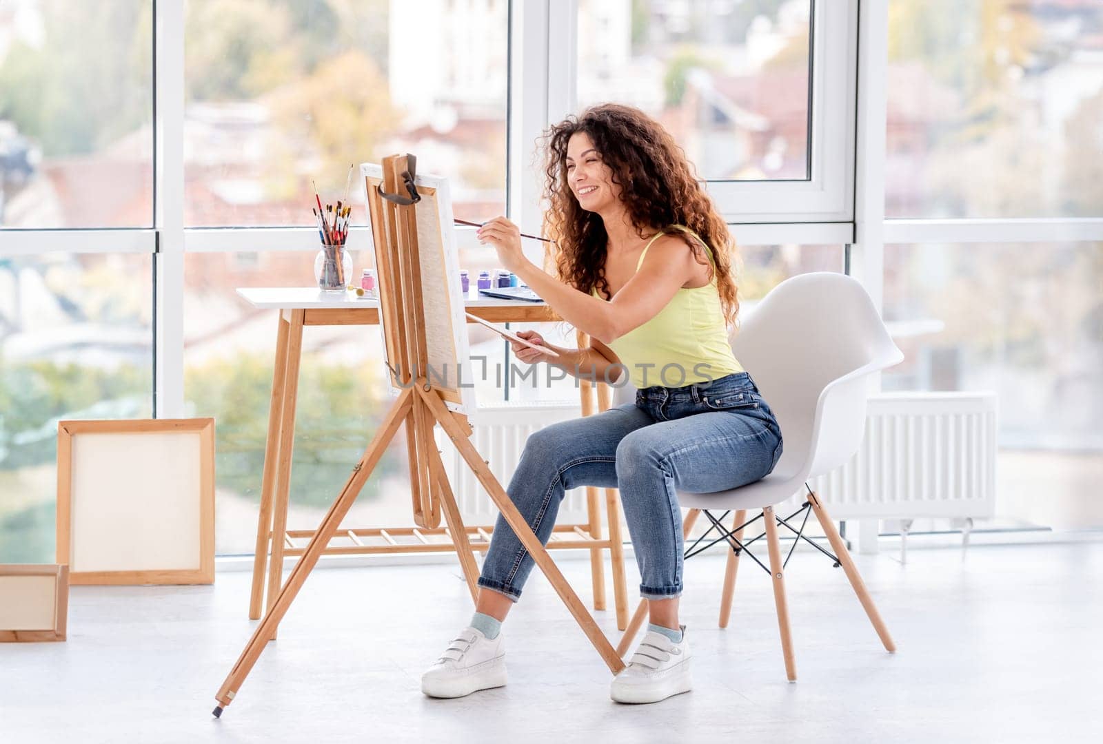 Smiling artist painting on easel by tan4ikk1