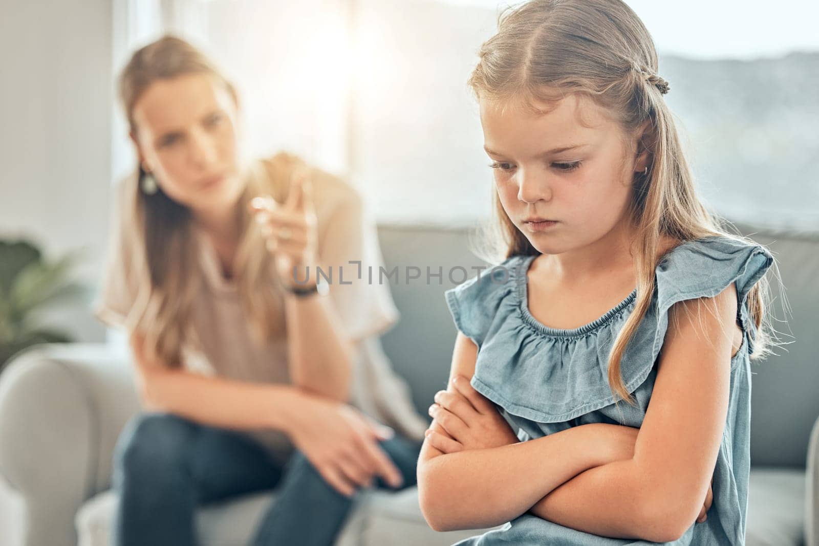 Angry lecture from mom, sad child and discipline in living room, problem with naughty girl behaviour in home. Scolding, punishment and frustrated mother, stubborn kid and communication with anger