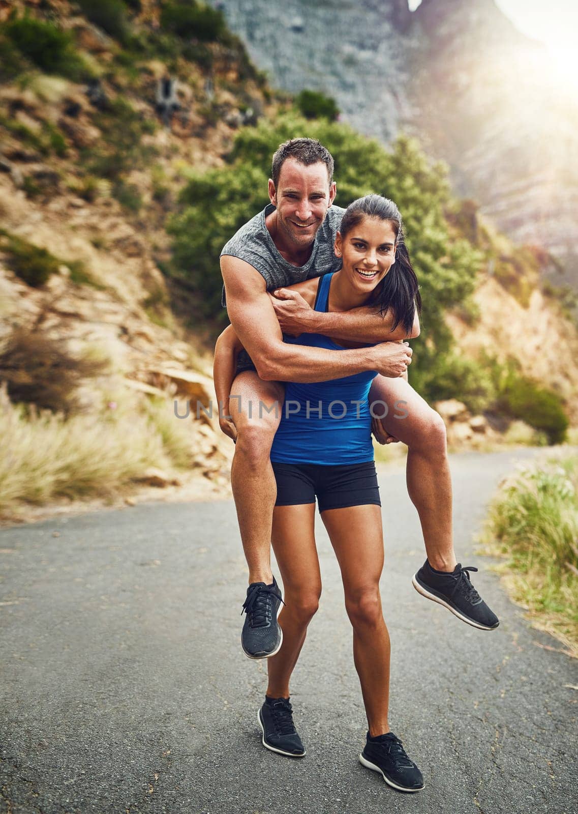 Im her weights. a young attractive couple training for a marathon outdoors. by YuriArcurs