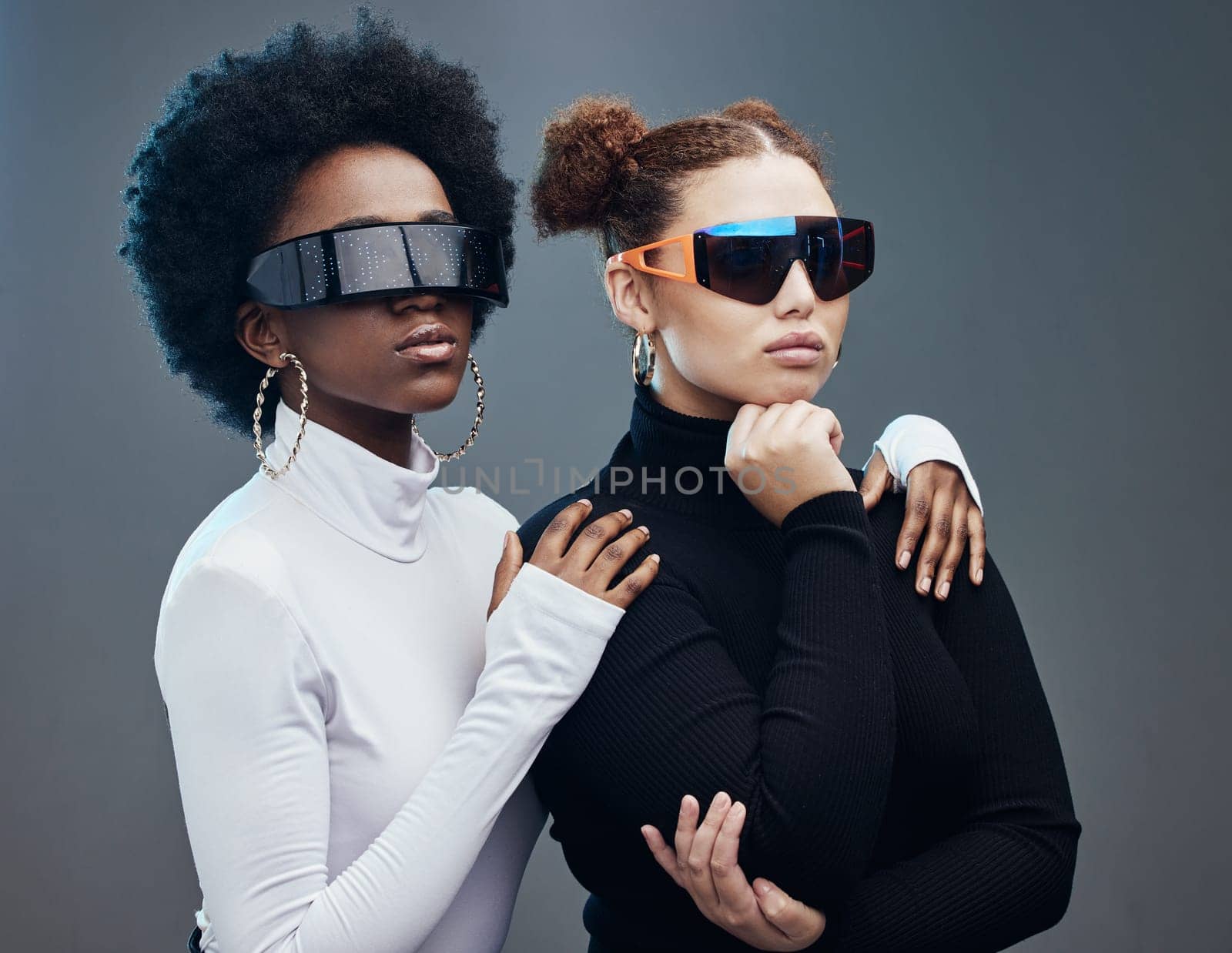 Fashion, futuristic and cyberpunk with women in sunglasses, young and trendy designer brand with gen z youth. Marketing, diversity and future style with vision and edgy against studio background by YuriArcurs