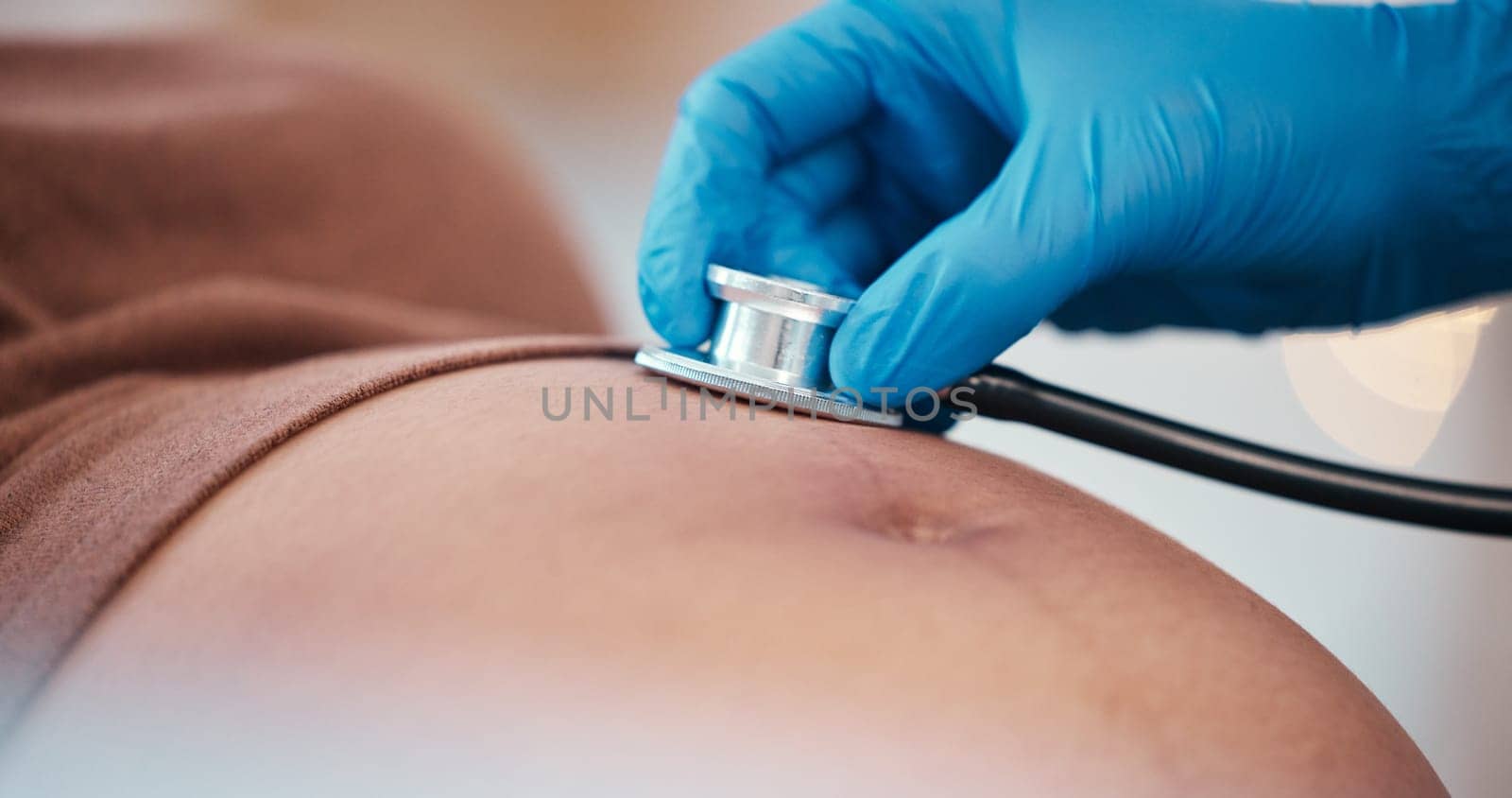 Healthcare, pregnancy and doctor with stethoscope on stomach for health check up of baby in utero. Pregnant black woman, doctors office and medical worker checking heart beat of child at hospital