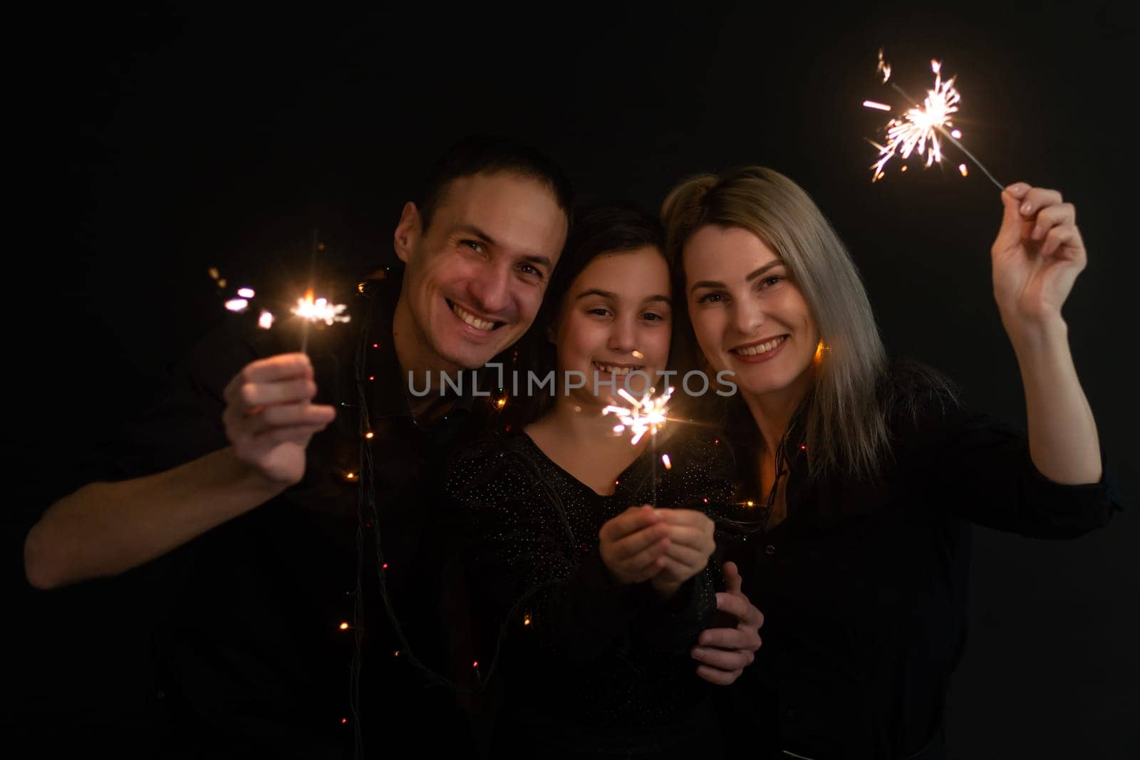 family with sparklers on a black background.