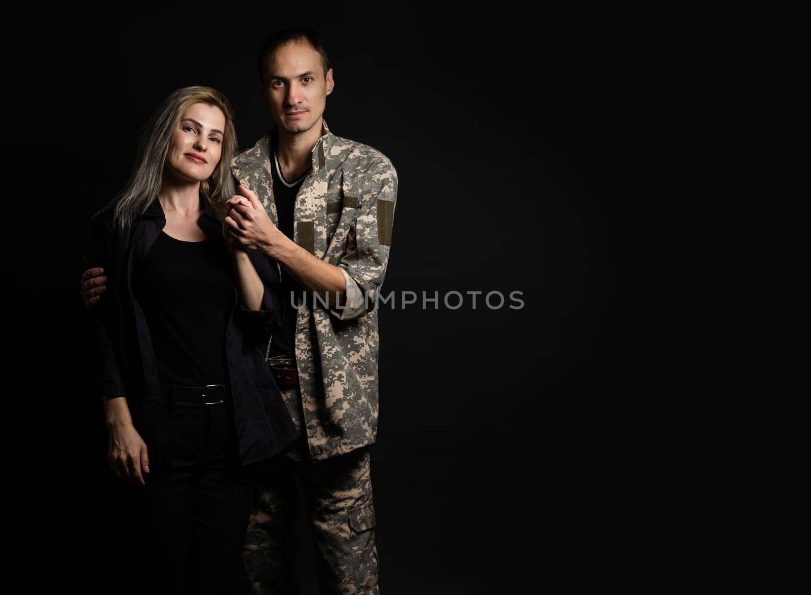 Happy woman hugging his husband came back from army. Smiling cheerful caucasian girlfriend embracing a soldier. by Andelov13