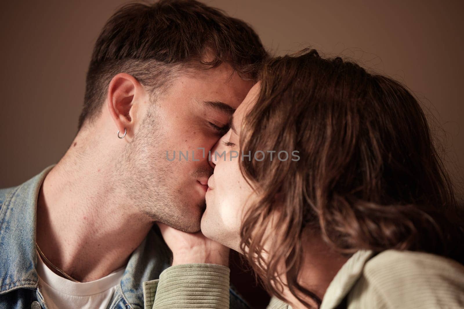 Couple kiss, love or gay men for trust, romance or support in studio with brown background. Happy, relax or LGBT people kissing for homosexual care, happiness or marriage anniversary date by YuriArcurs