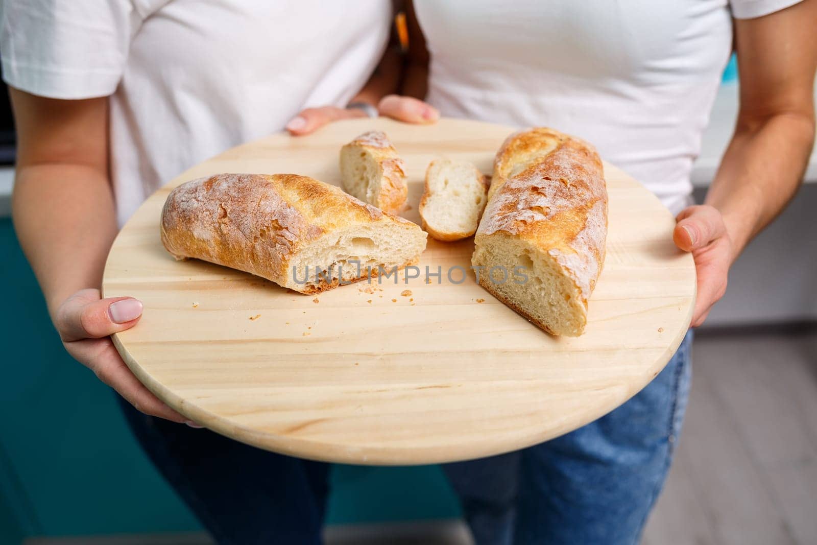 Baker's hands break hot fresh wheat bread into two halves, crunch and crumbs. selective focus