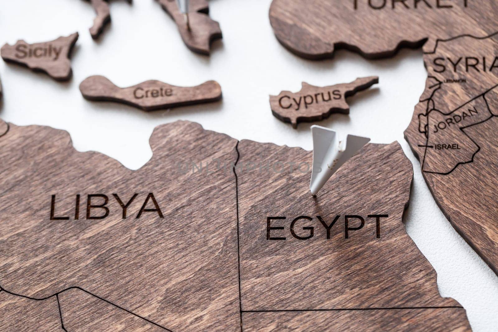 A wooden map of the world is glued to the wall on it marks with countries that have visited