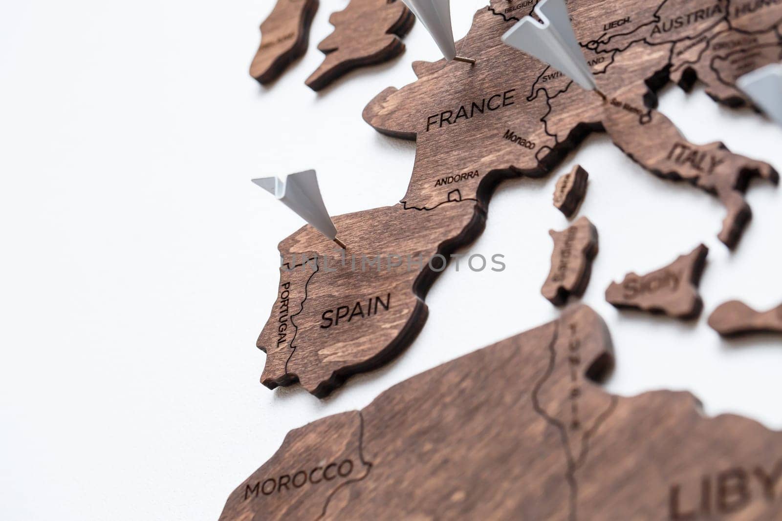 A wooden map of the world is glued to the wall on it marks with countries that have visited
