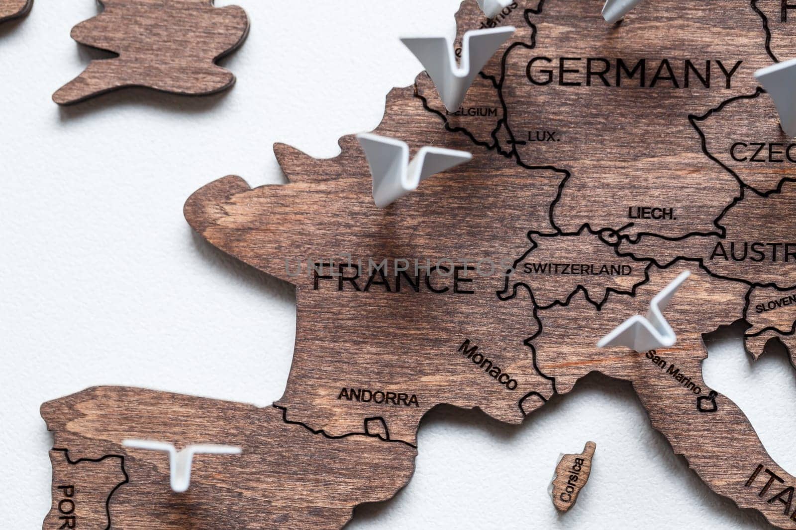 A wooden map of the world is glued to the wall on it marks with countries that have visited