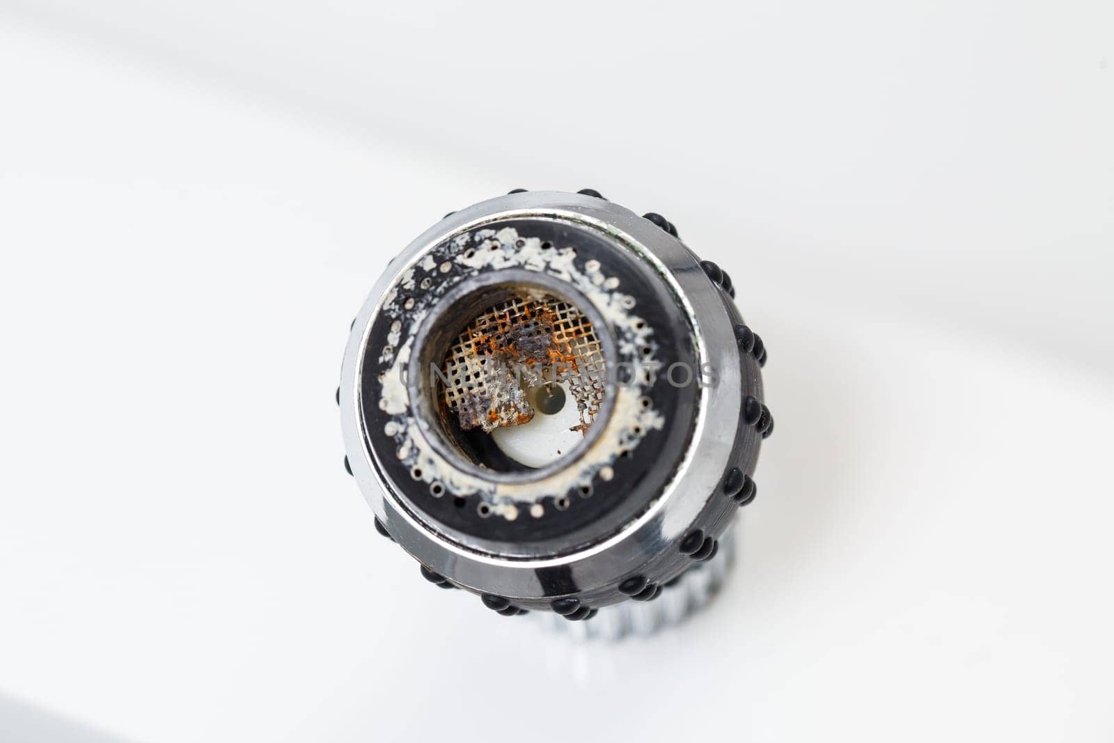 Old faucet aerator close-up on a white background. Broken sink mixer