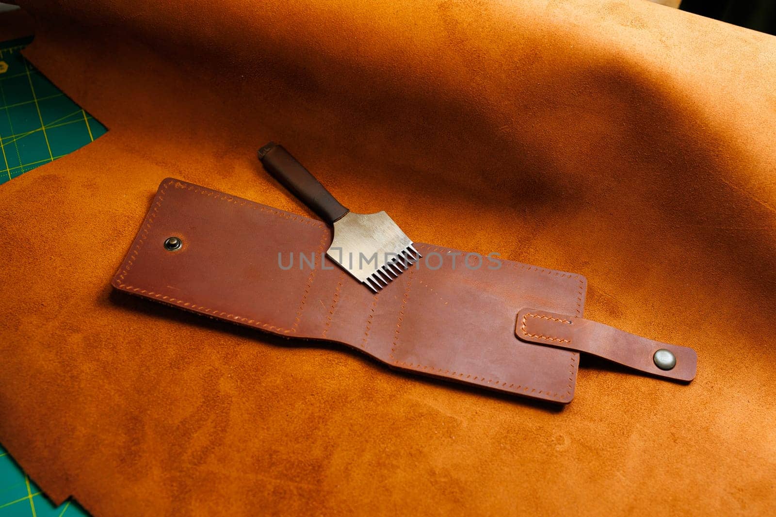 The process of production of leather goods. Materials and tools for leather production. Beautiful brown leather products and tools for needlework.