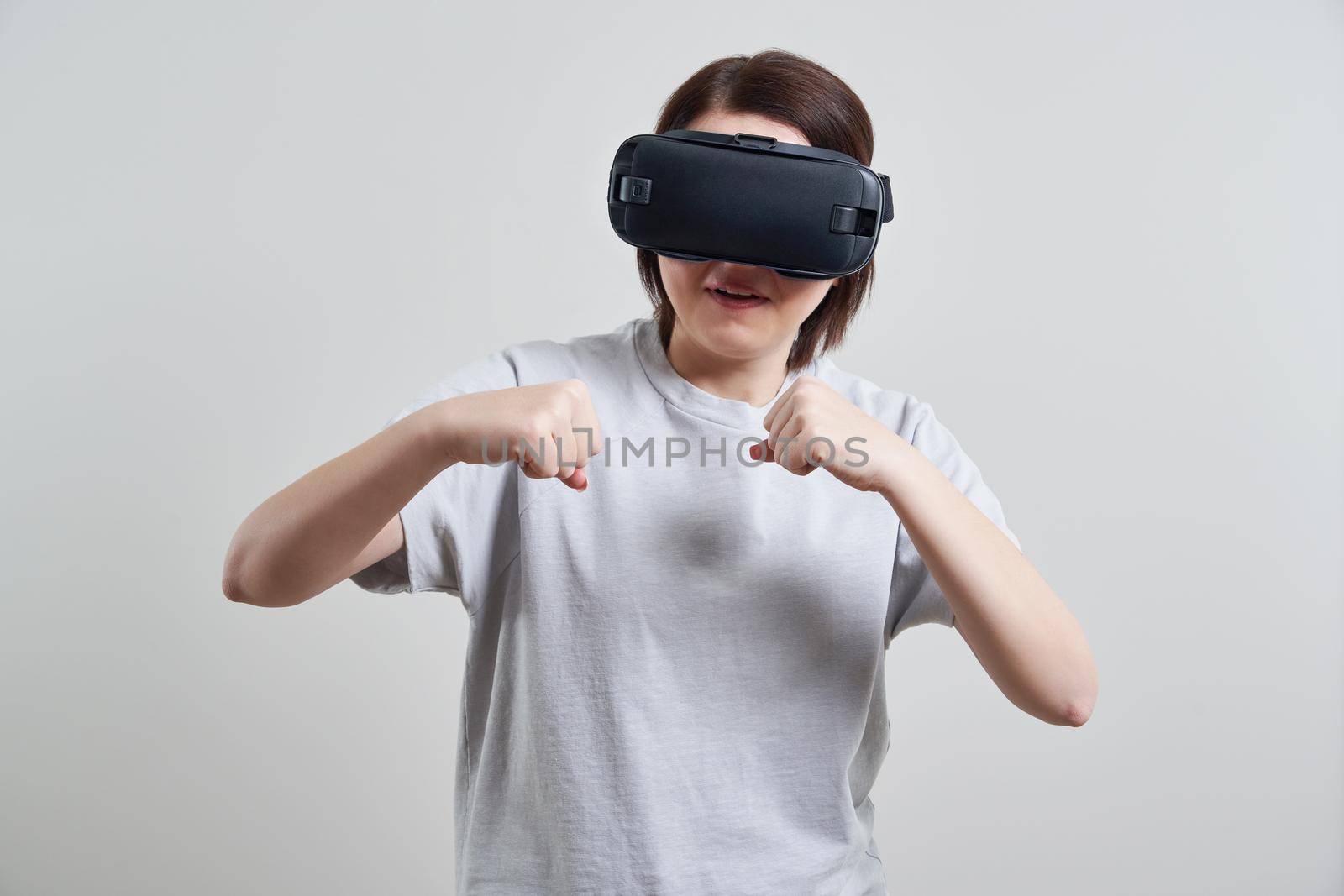 Happy young woman playing on VR glasses indoor. Virtual reality concept with young girl having fun with headset goggles.