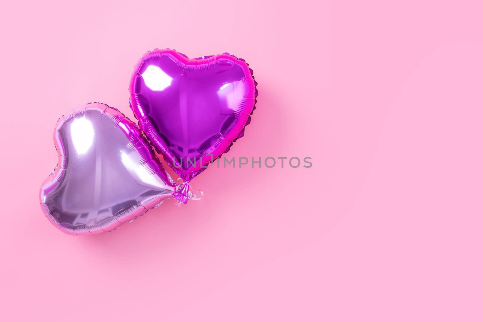 Valentine's Day minimal design concept - Beautiful real heart shape foil balloon isolated on pale pink background, top view, flat lay, overhead above photography. by ROMIXIMAGE