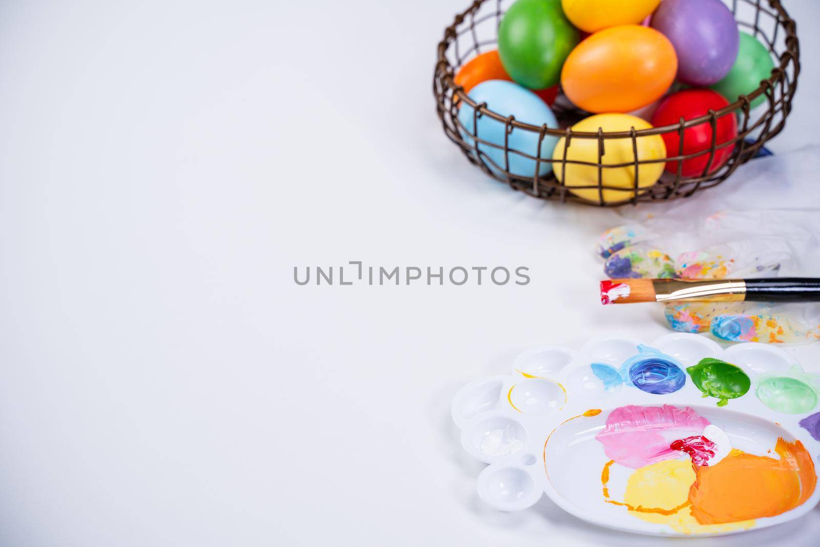 Design concept - Preparing for Easter celebration, painting Easter eggs with colorful Acrylic pigment color dyestuff in palette, top view, lifestyle.