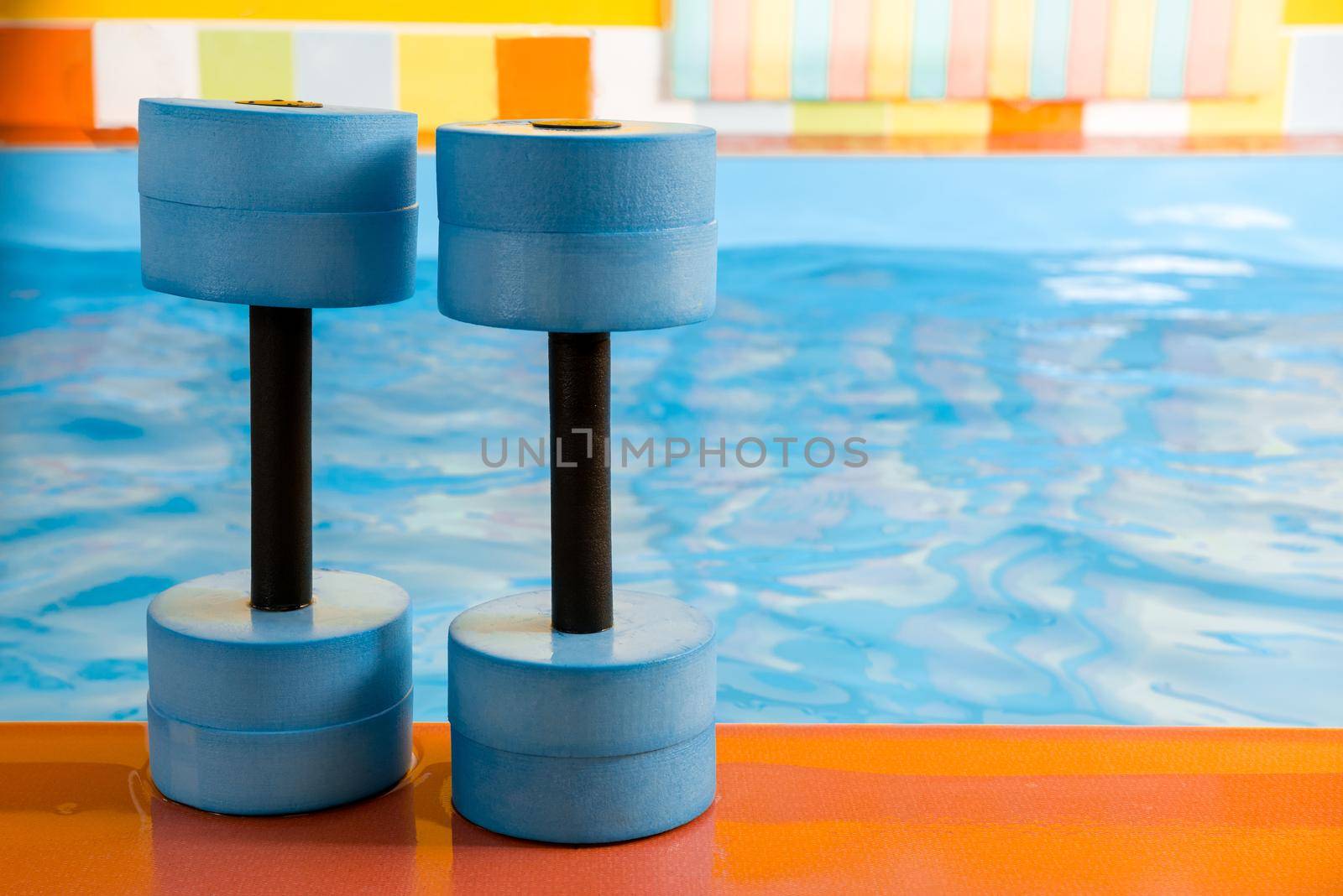 dumbbells equipment for aqua aerobics sport near a swimming pool