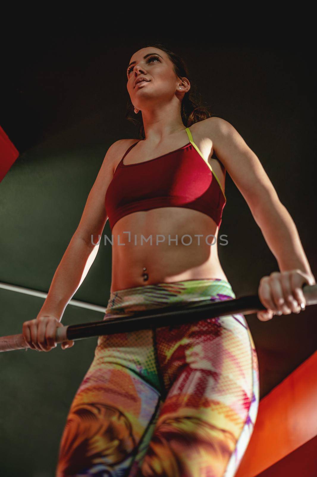 Beautiful young strong muscular woman doing pull-up exercise at the gym. 