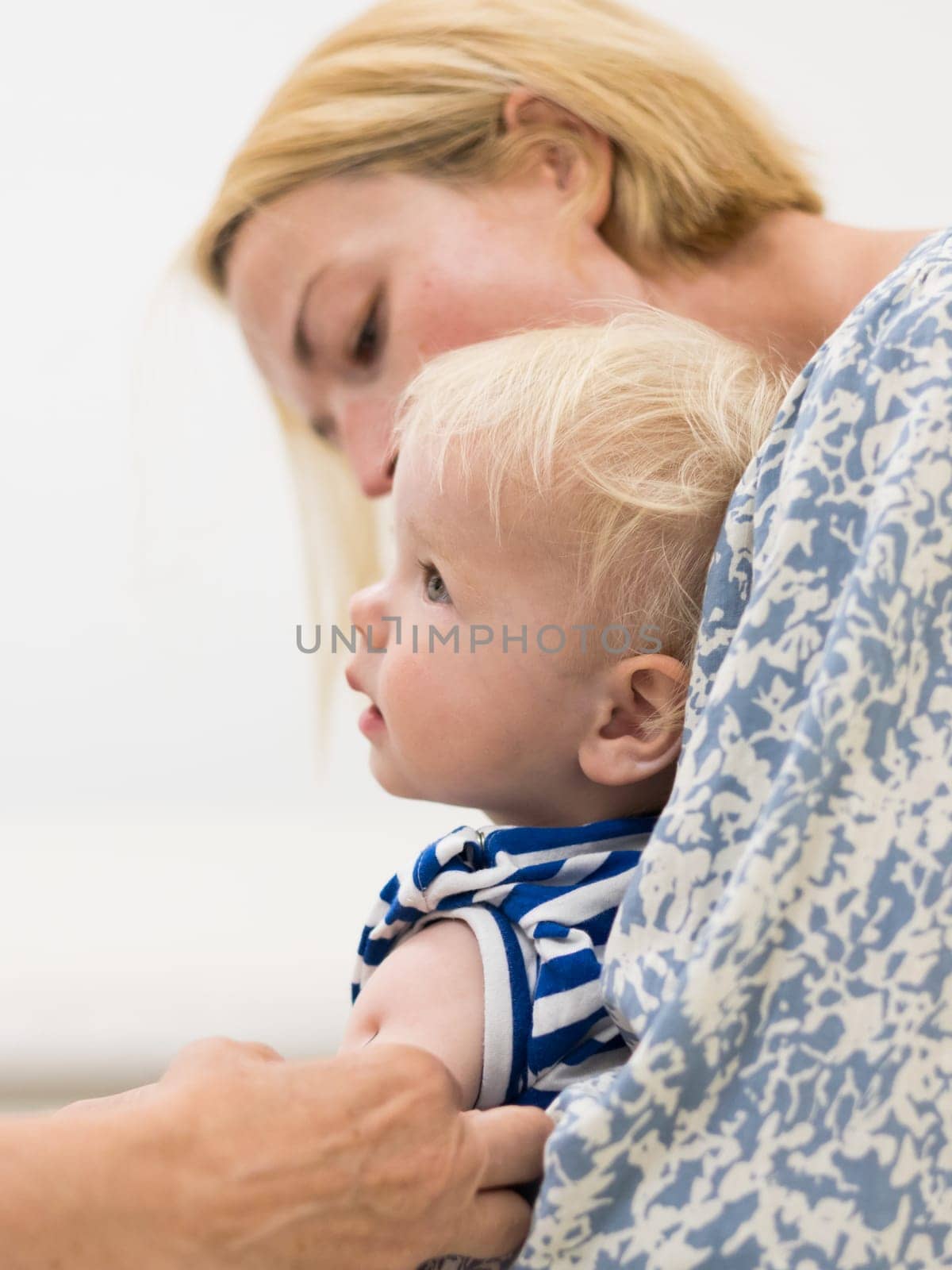 child beeing vaccinated by pediatrician in presence of his mother. Preventive vaccination against Diphtheria, whooping cough, tetanus, hepatitis, haemophilus influenzae, pneumococcus, poliomyelitis.