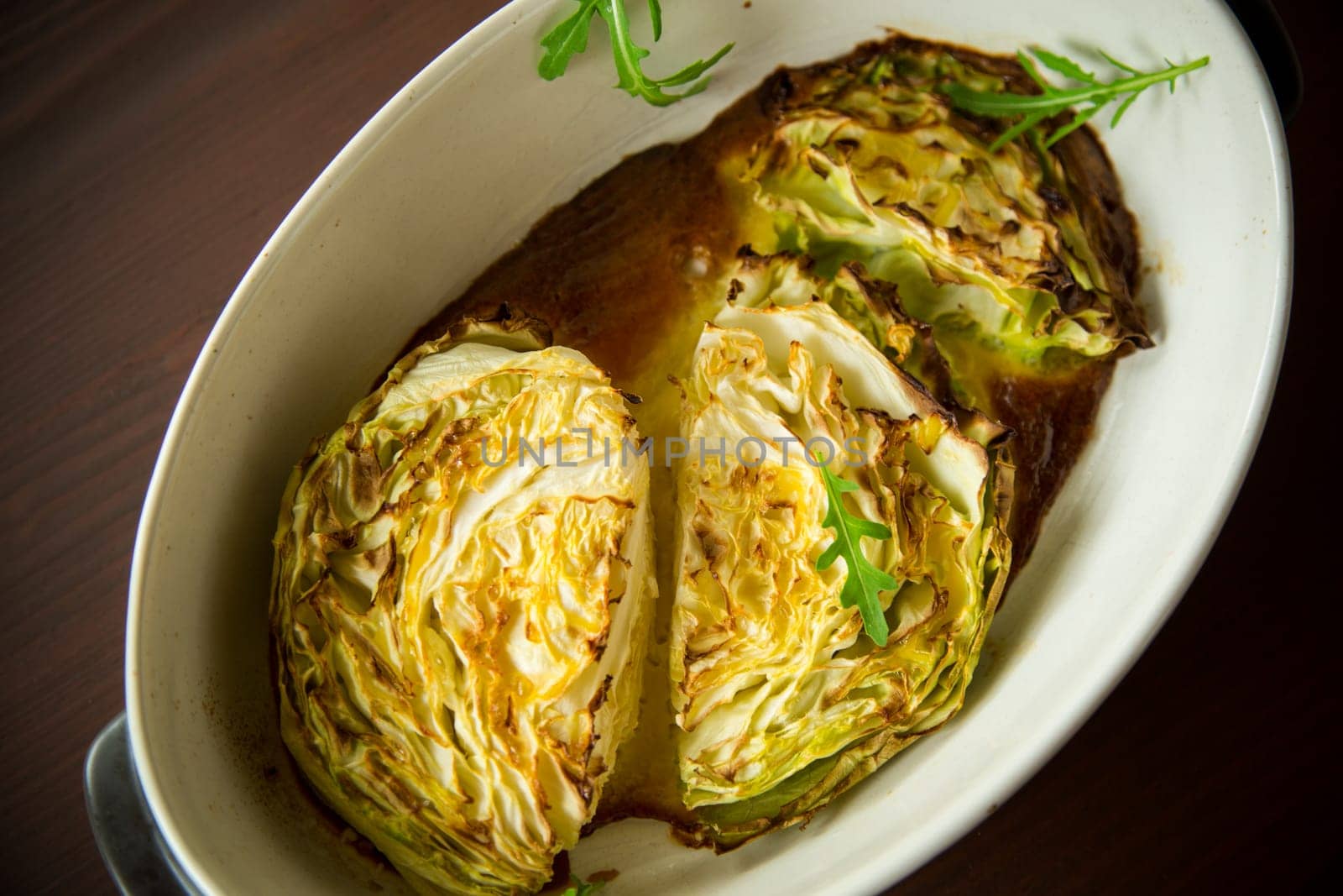 Young early cabbage baked in pieces in the oven, in a ceramic form.