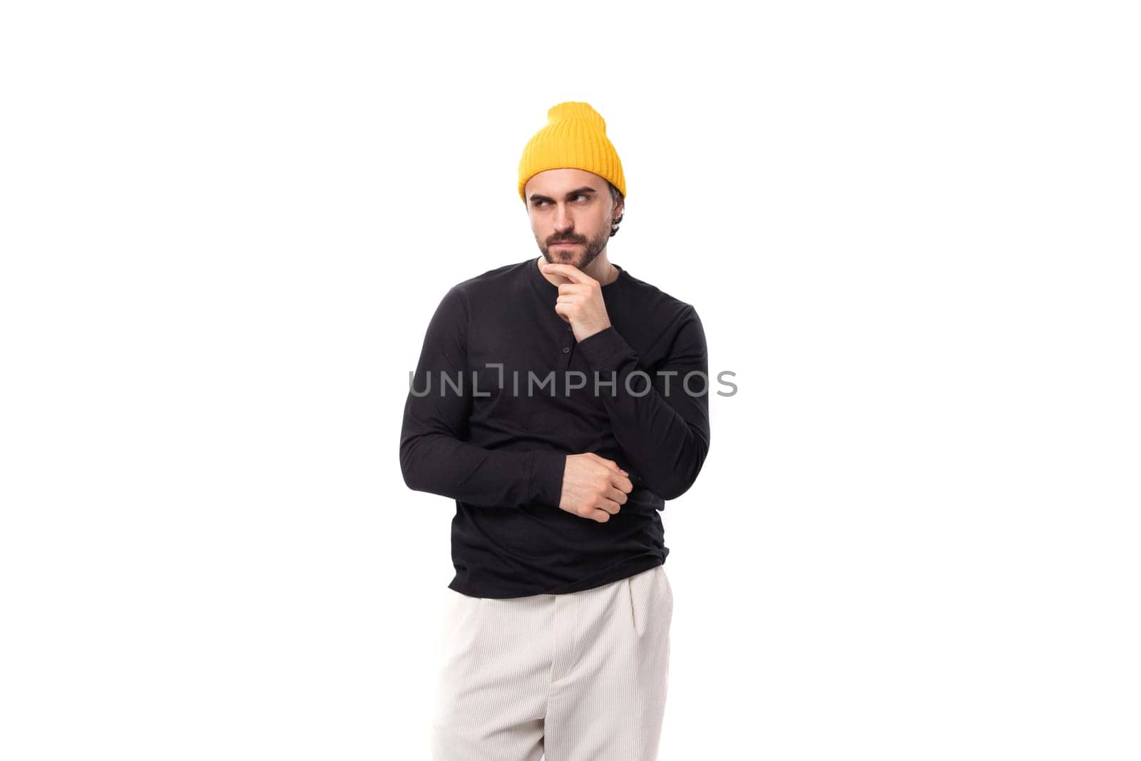 young brutal brunette european brutal man in a black sweatshirt on a white background with copy space by TRMK