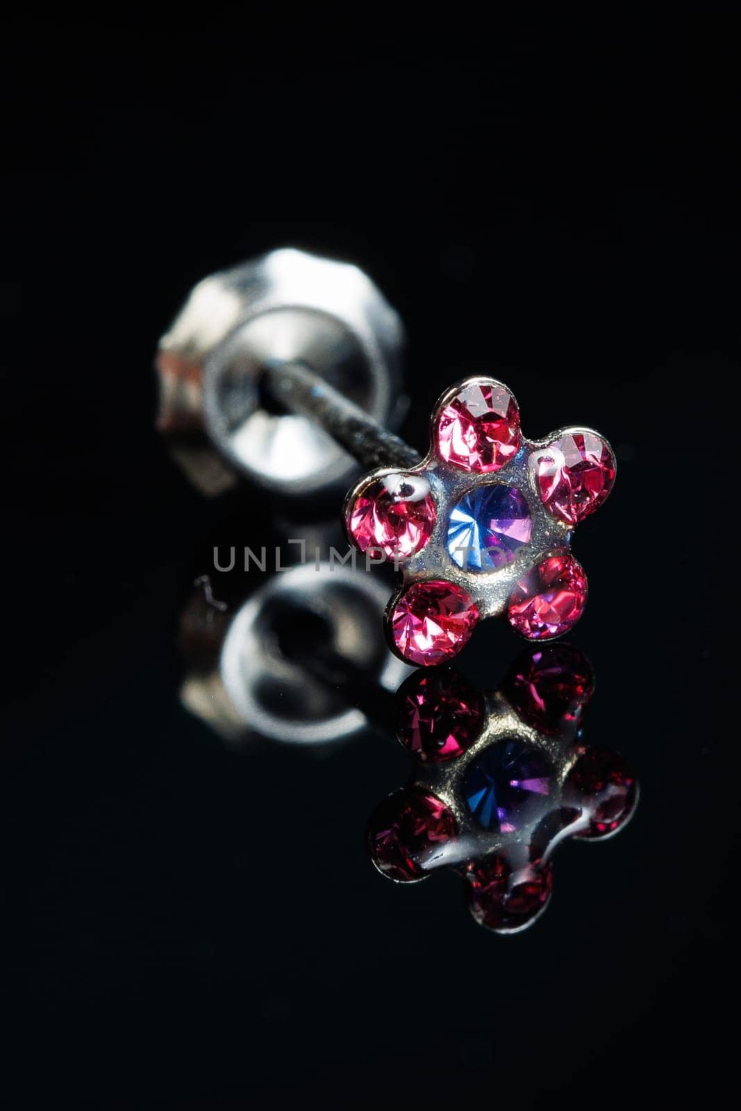 Jewelry with stone earrings, luxury silver earrings with diamonds, sapphires on a black background. Selective focus.