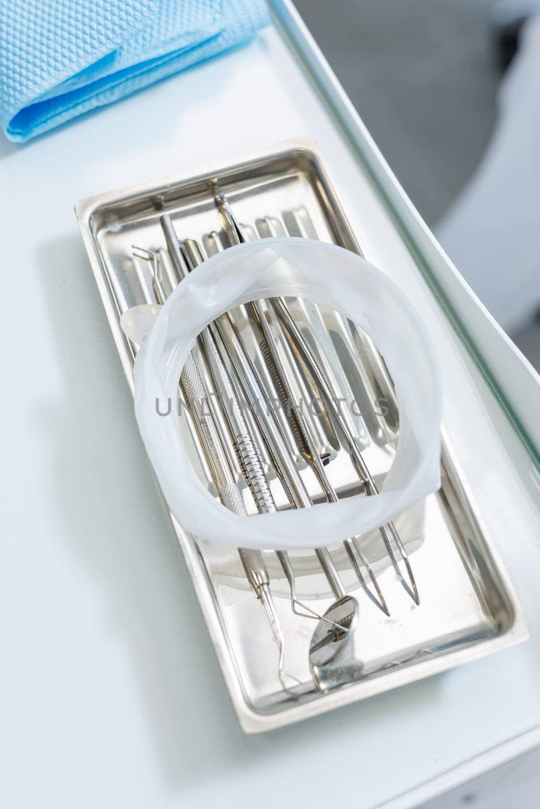 Tray with metal dental tools. Tools of the dentist. Interior of a patient reception room with dental equipment in a dental clinic.