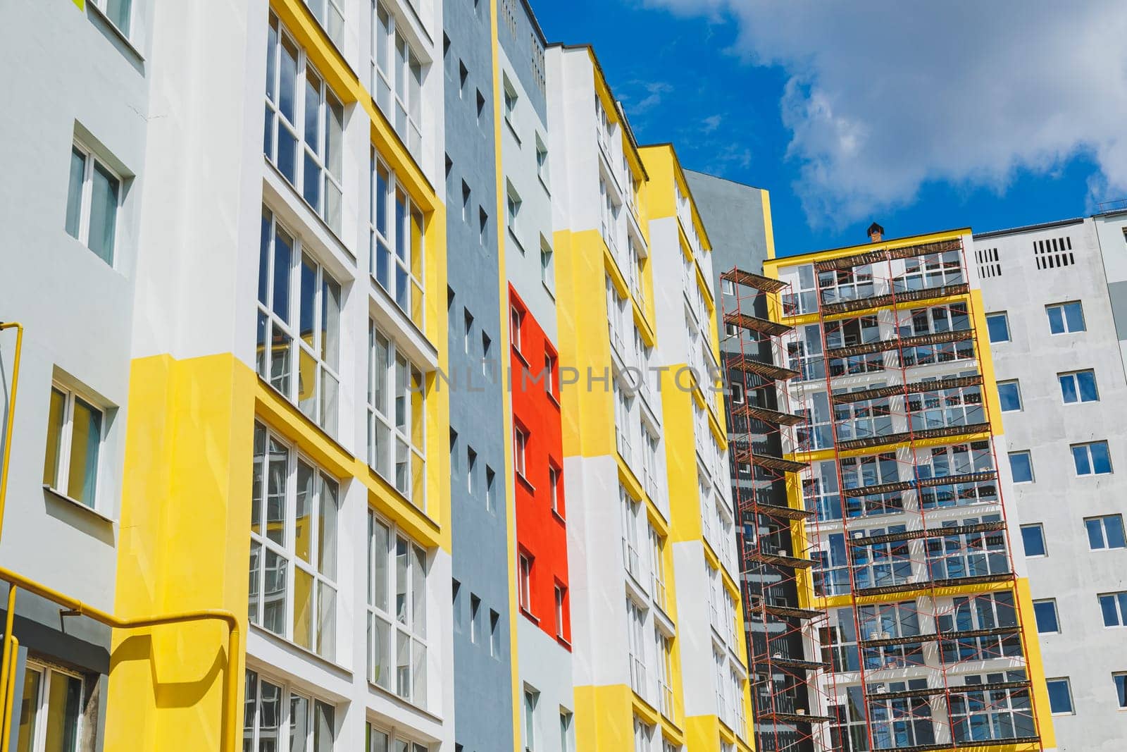 Detail in Modern residential flat apartment building exterior. Fragment of New luxury house and home complex. Part of City Real estate property and condo architecture. Copy space. Blue sky