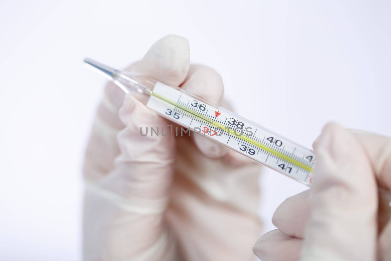 diseased woman in protective medical surgical mask with a thermometer in his hand treated against the virus. Isolated on white background