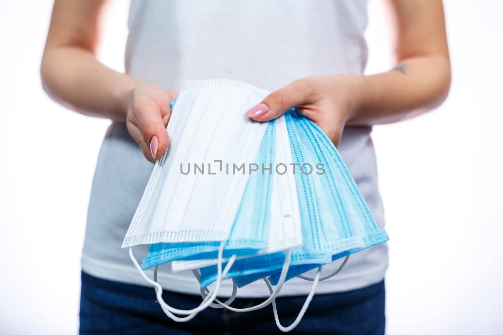 A girl in a protective medical mask holds in her hands means to protect the respiratory tract from the virus.