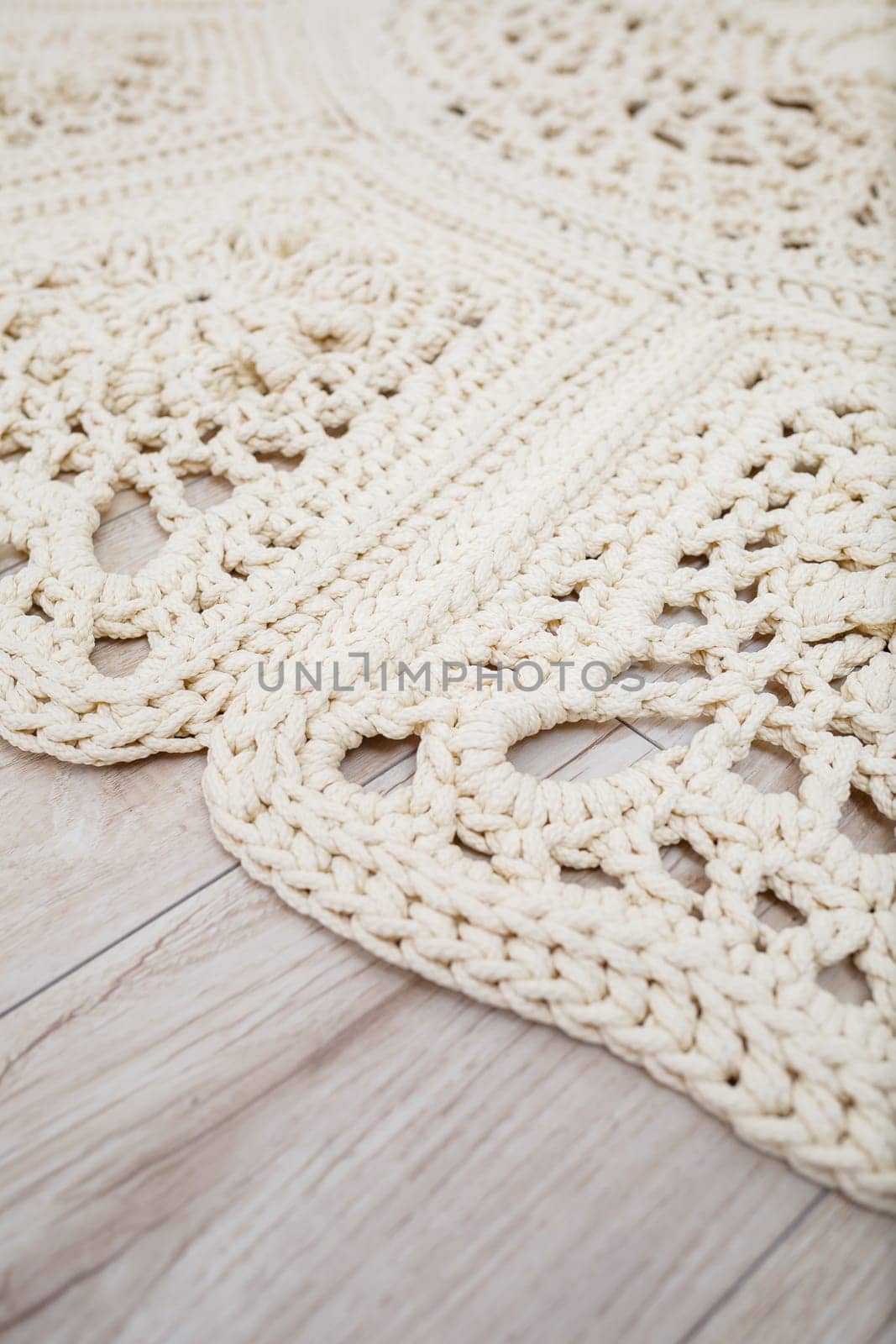 Handmade carpet knitted from natural threads, flooring, natural cotton. Beige handmade carpet. Knitted decorative item