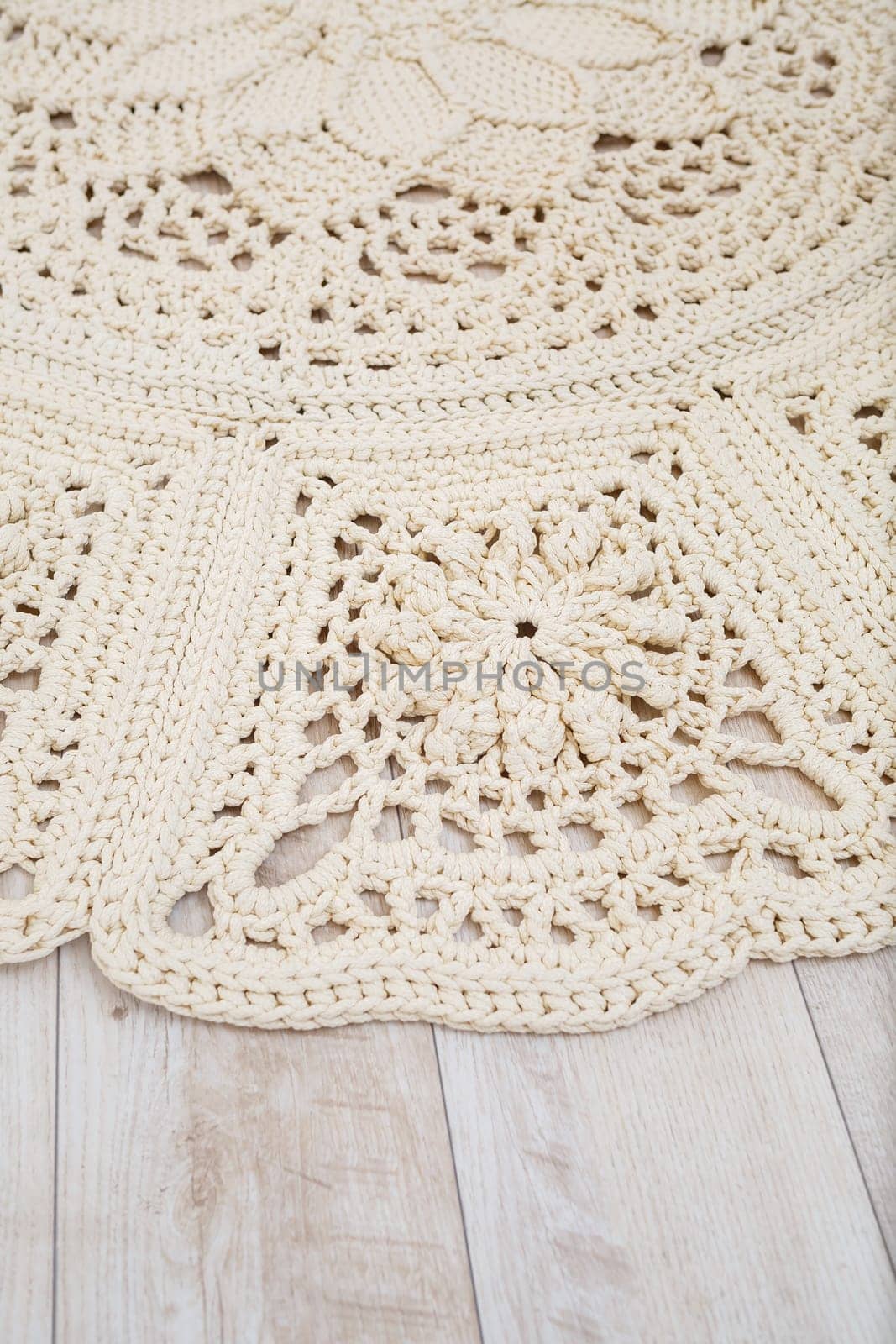 Handmade carpet knitted from natural threads, flooring, natural cotton. Beige handmade carpet. Knitted decorative item