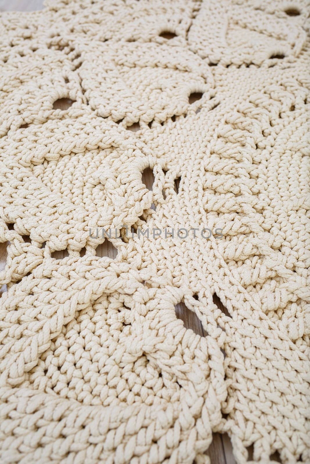 Handmade carpet knitted from natural threads, flooring, natural cotton. Beige handmade carpet. Knitted decorative item