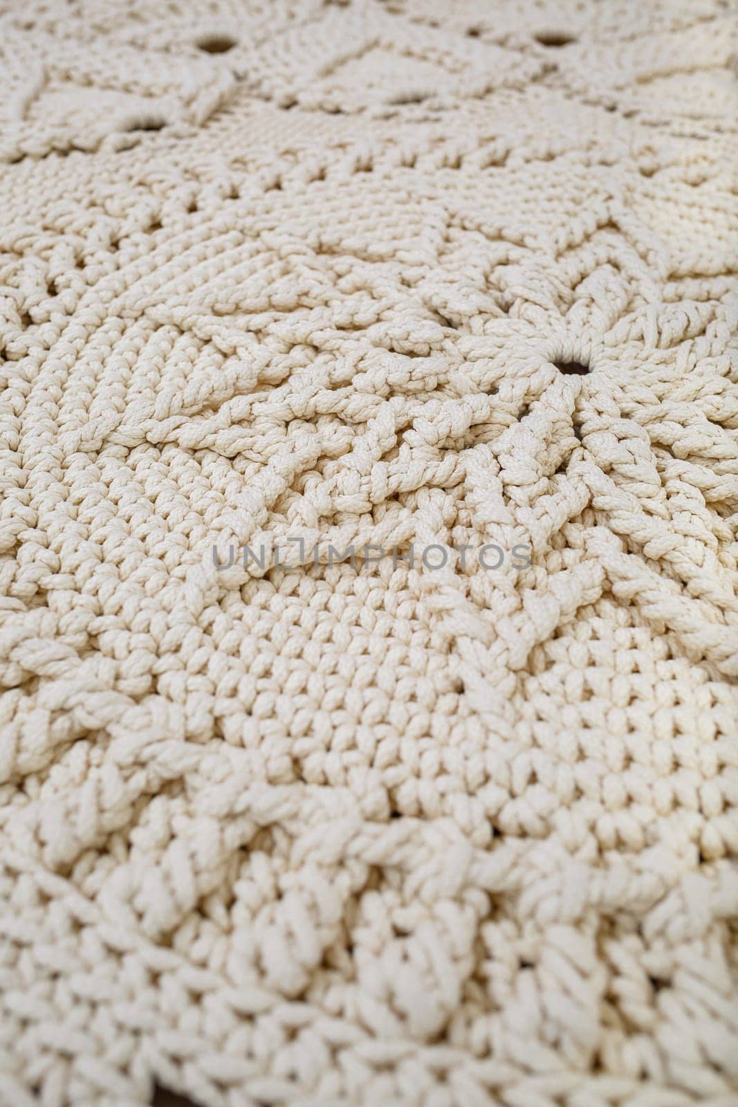 Handmade carpet knitted from natural threads, flooring, natural cotton. Beige handmade carpet. Knitted decorative item