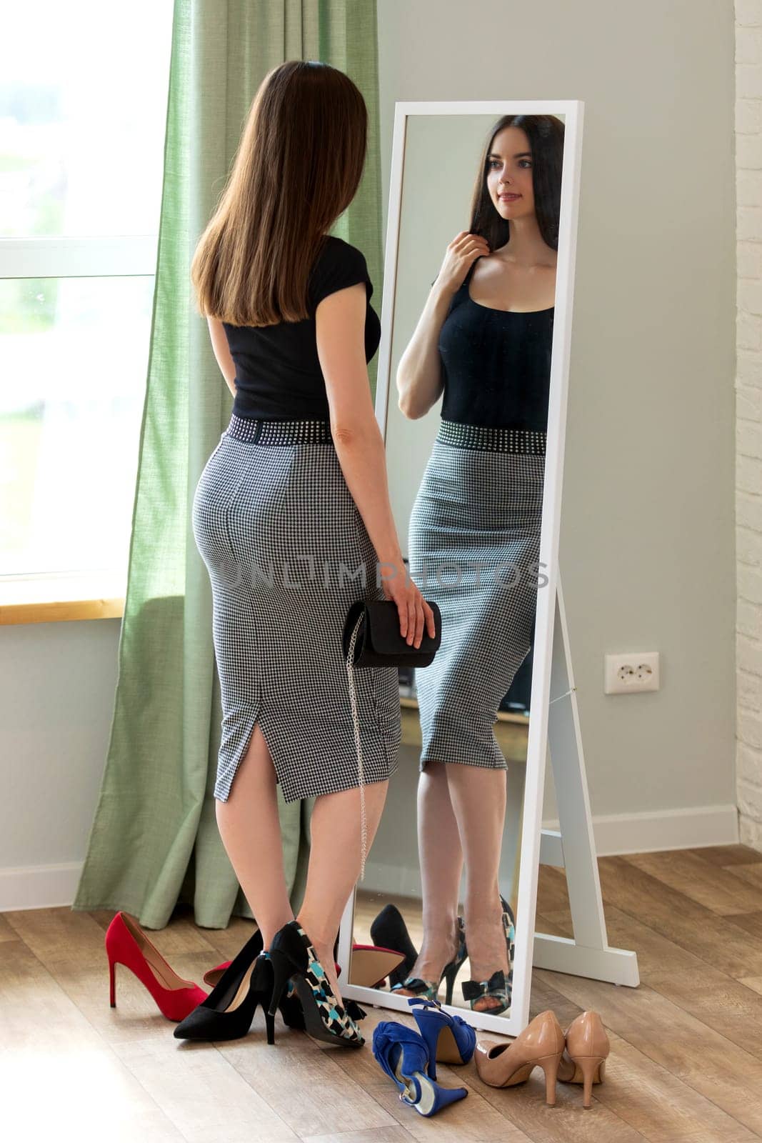 Young woman looking at her reflection in the mirror