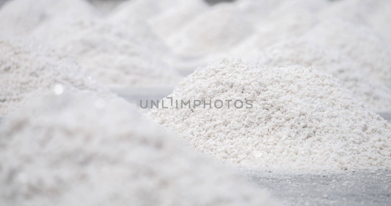 Sea salt farm. Pile of brine salt. Raw material of salt industrial. Sodium Chloride mineral. Evaporation and crystallization of sea water. White salt harvesting. Agriculture industry. Traditional farm by Fahroni