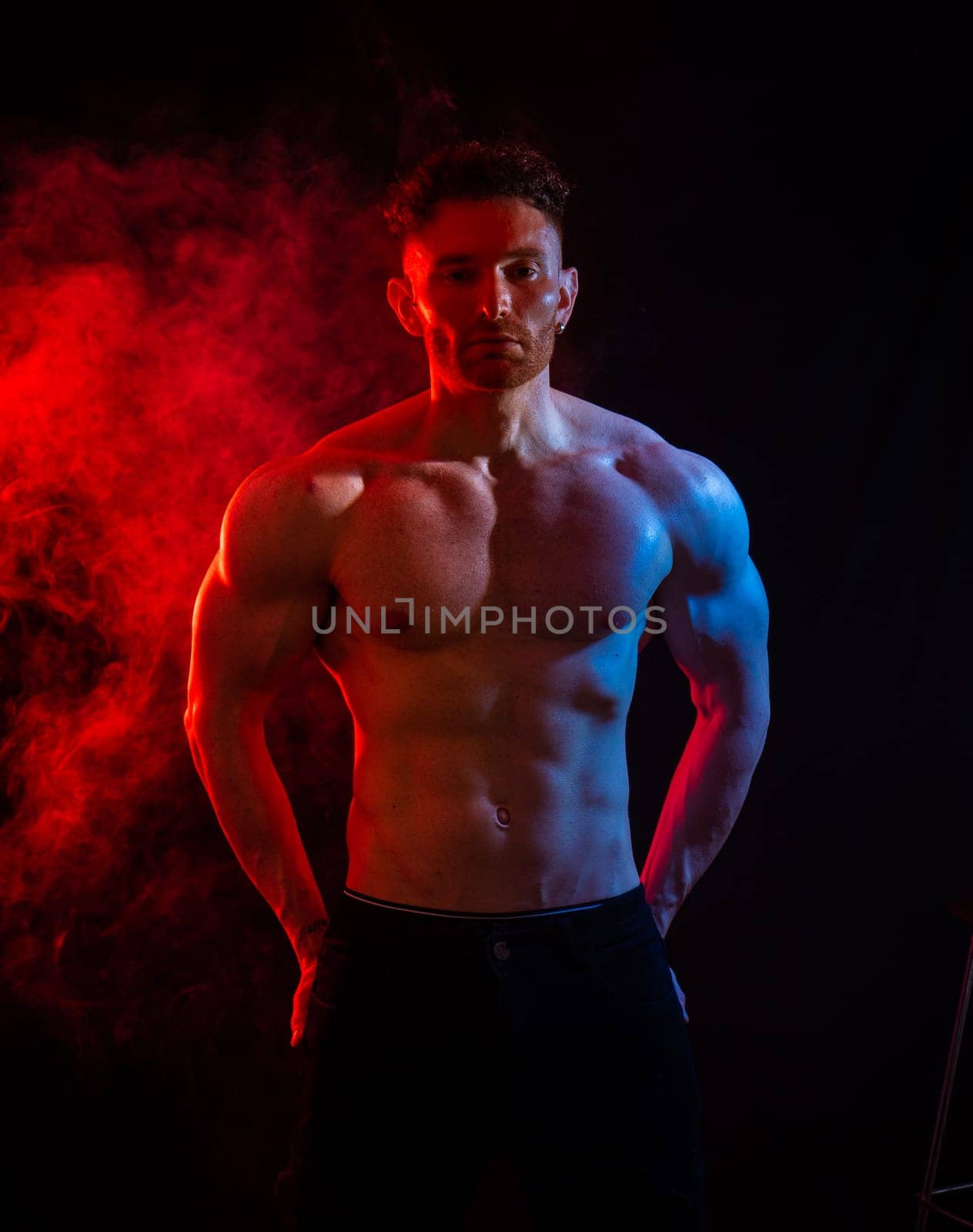 Handsome male bodybuilder in studio shot, with dramatic lighting, wearing briefs,