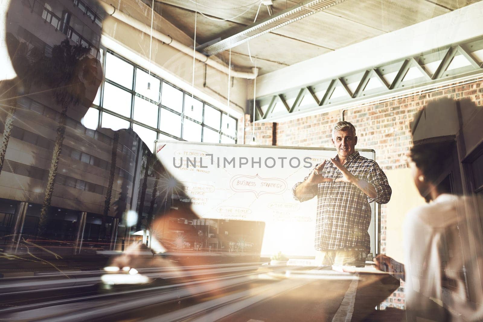 Multiple exposure shot of businesspeople having a meeting superimposed over a cityscape.