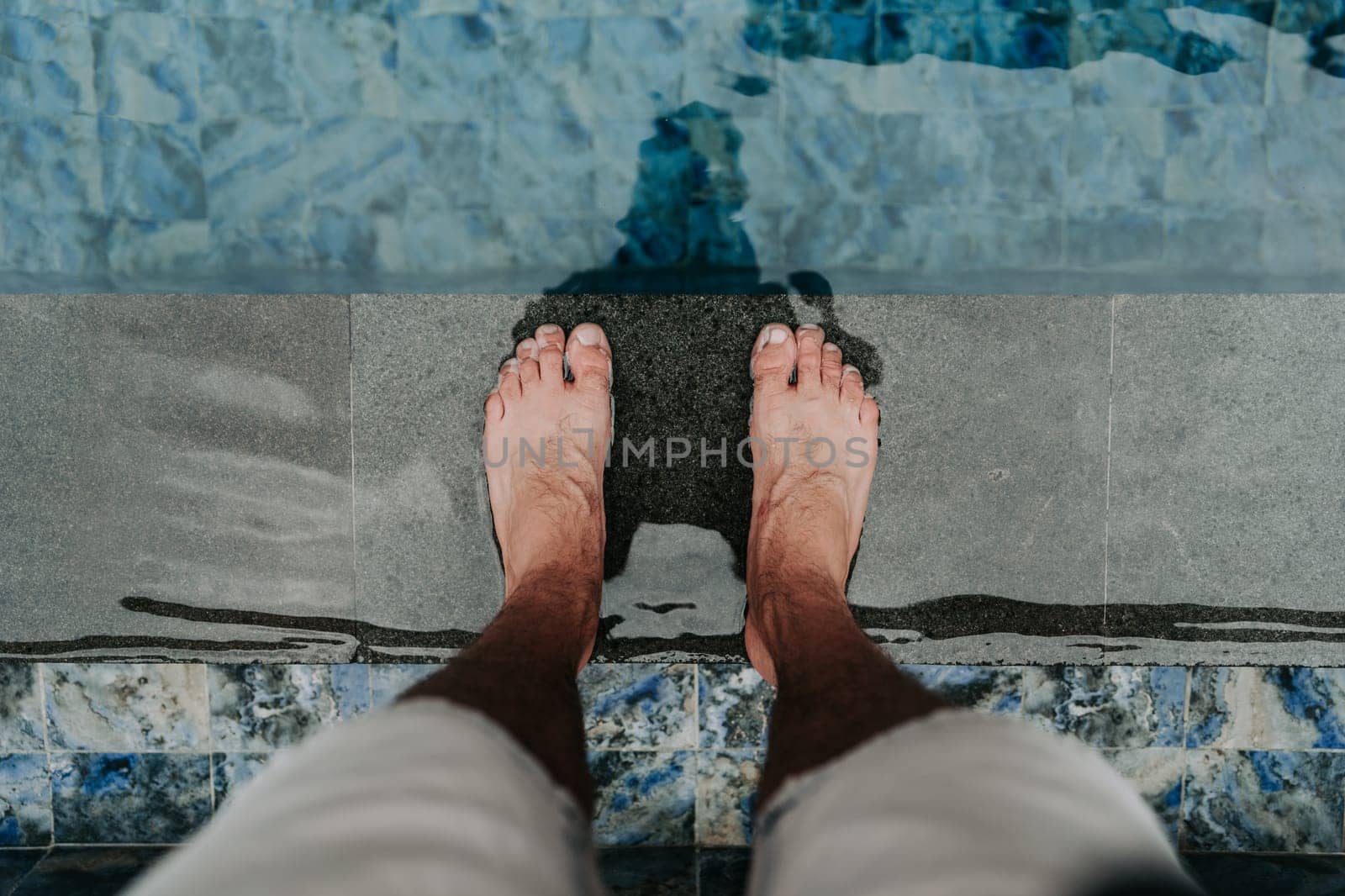 Person's feet on a pool edge by Popov