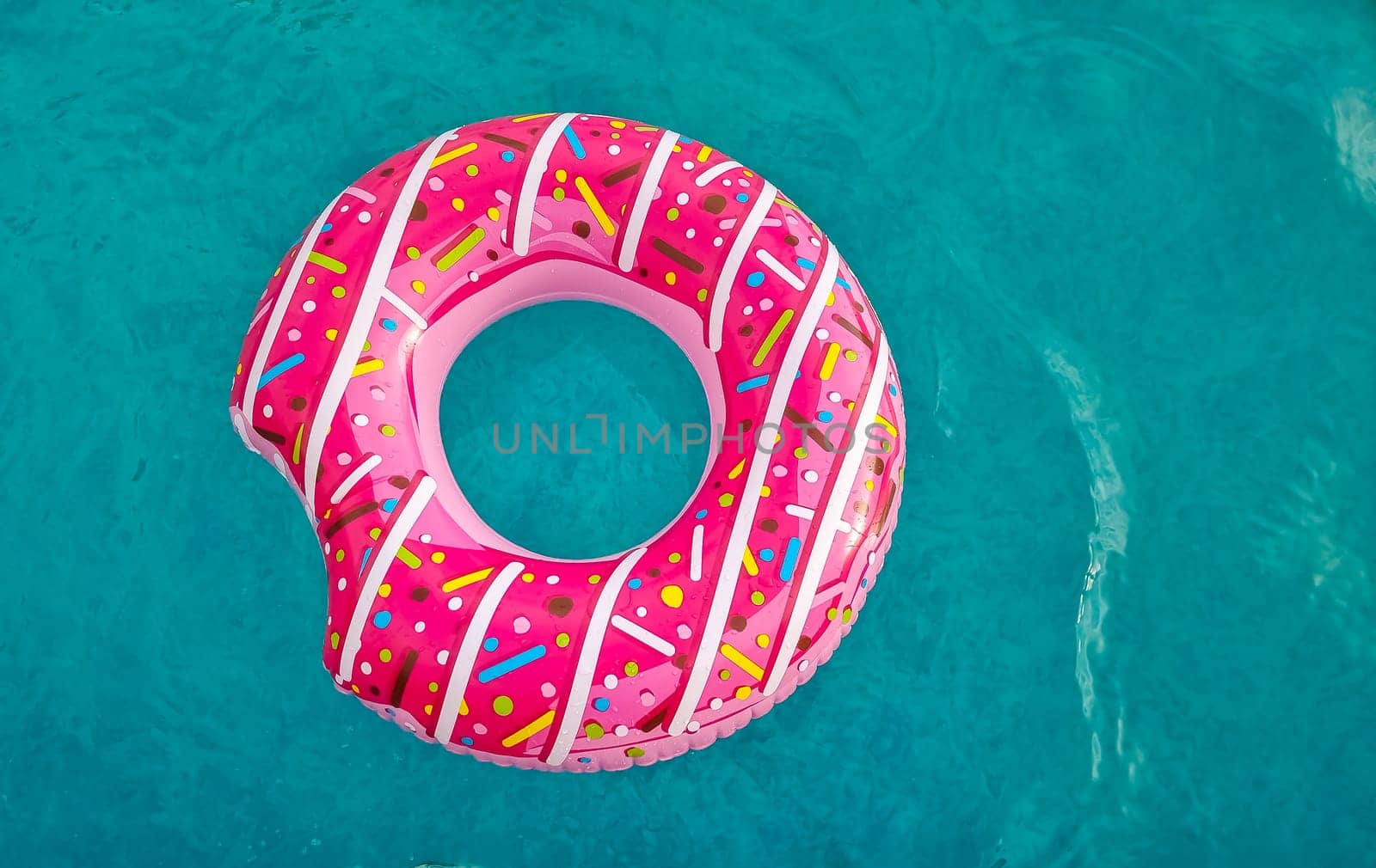 Yellow inflatable ring floating in swimming pool. Vacation concept with copy space