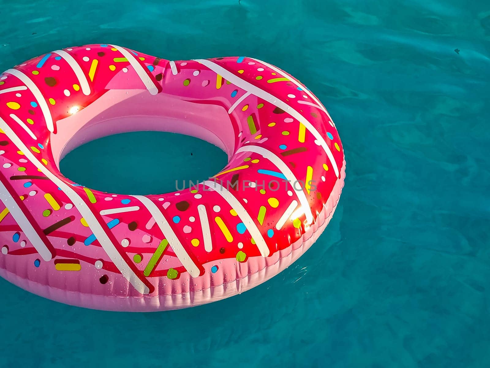 Yellow inflatable ring floating in swimming pool. Vacation concept with copy space