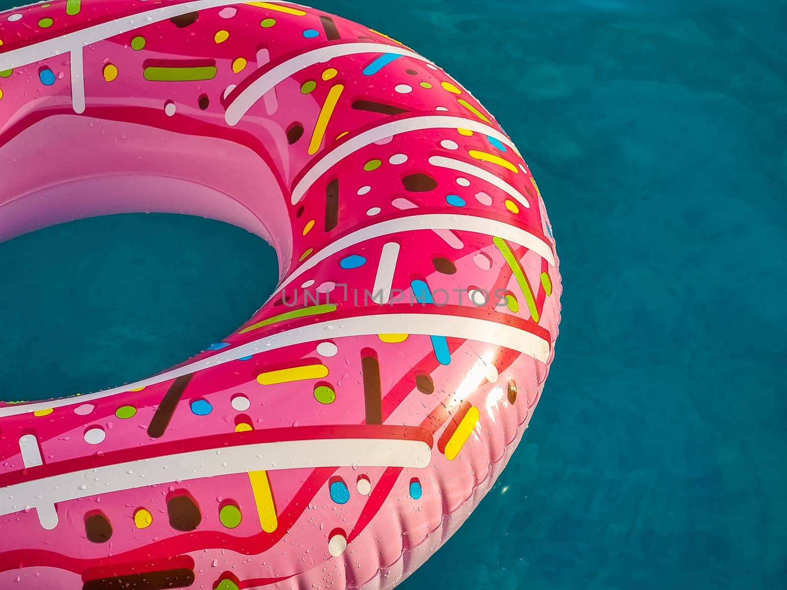 Yellow inflatable ring floating in swimming pool. Vacation concept with copy space