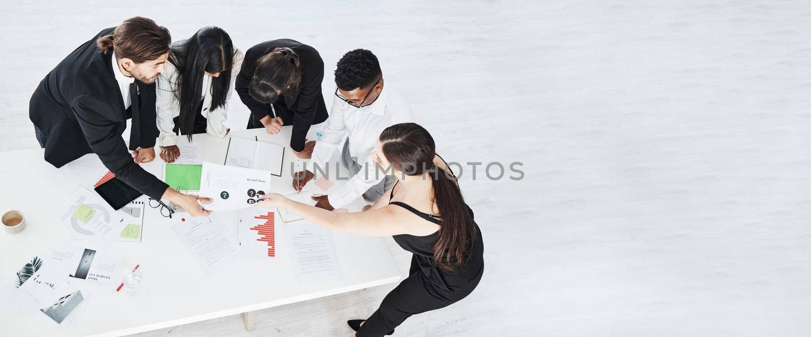 Meeting, finance and collaboration with a business team working around a table in the boardroom from above. Accounting, documents and teamwork with a man and woman employee group at work in an office.