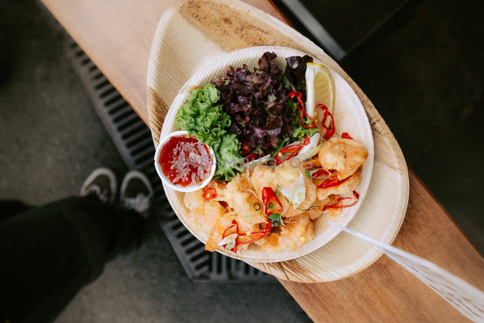 Fried calamari with fresh salad on a seafood street food market