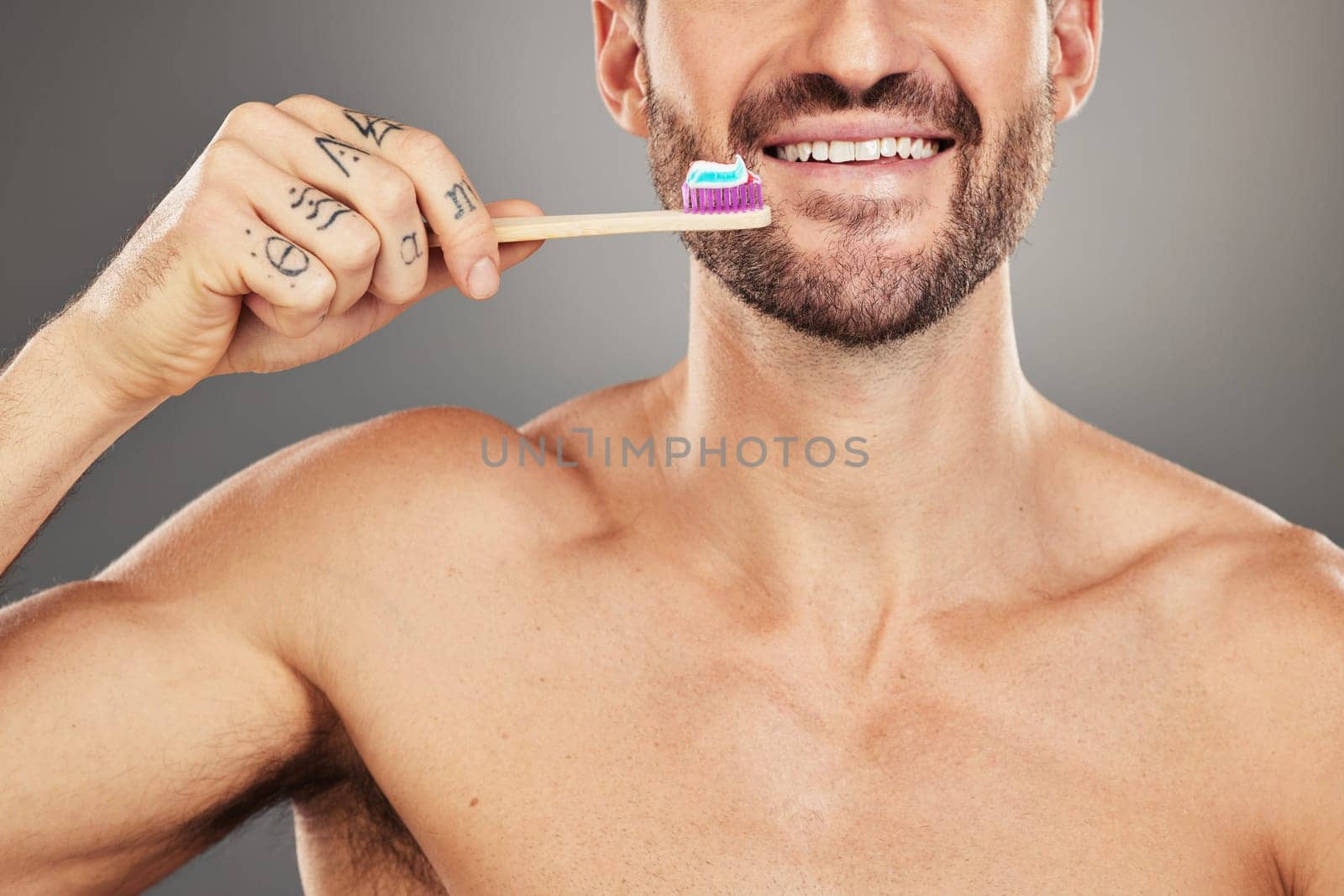 Health, dental or man with toothbrush for teeth, dental hygiene or happy face on a grey studio background. Oral, smile or face zoom portrait of healthy male with brush for healthcare wellness model.