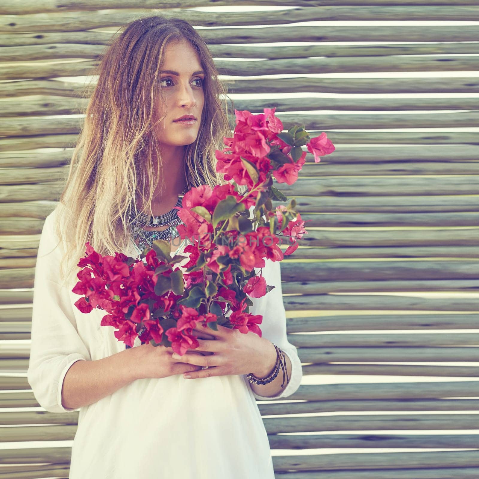 Making a fashion statement with flowers. an attractive young woman holding a bunch of fresh flowers. by YuriArcurs