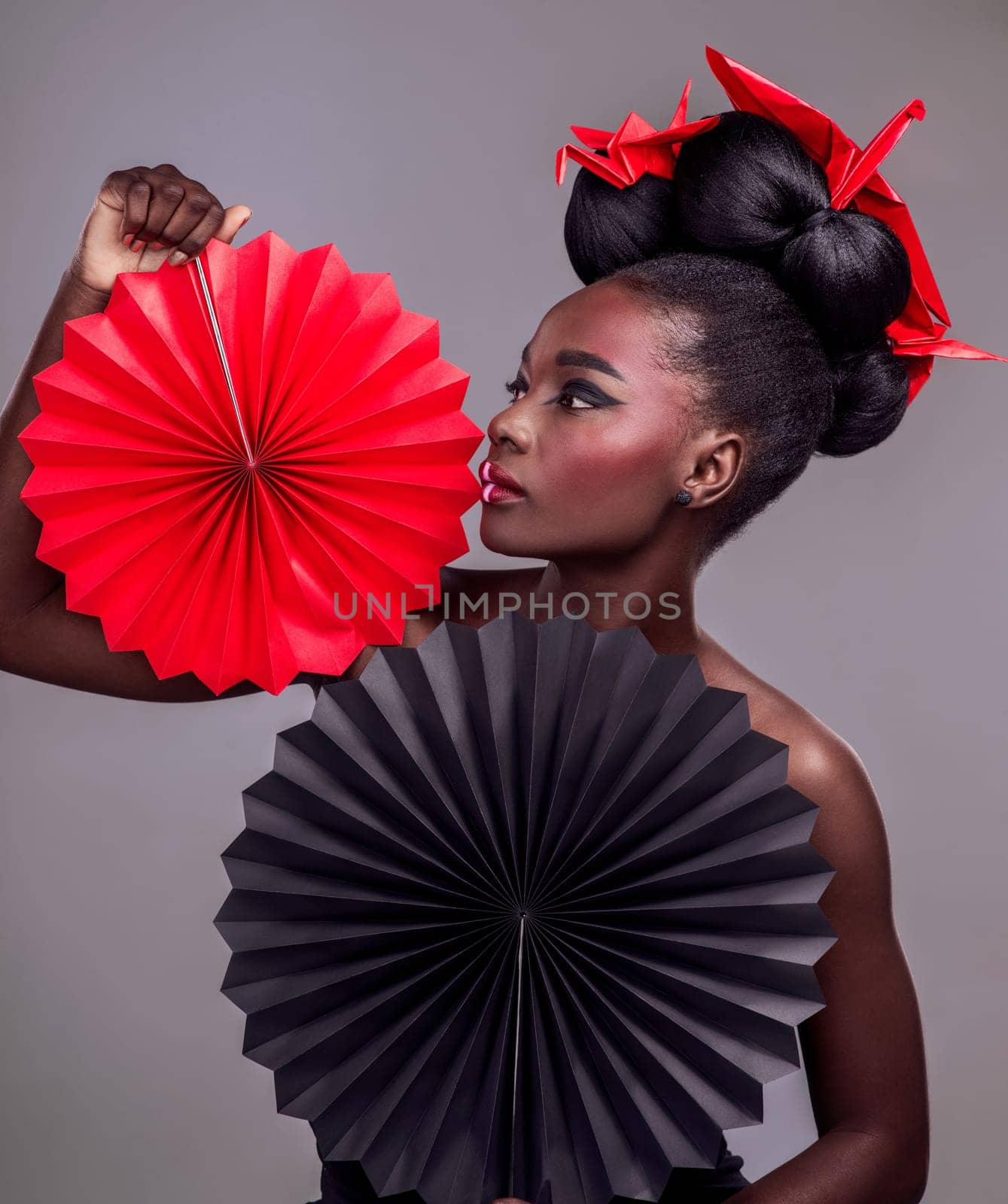 Art, makeup and creative with black woman in studio for origami, beauty and culture. Traditional, cosmetics and paper design with female model and fans on grey background for fashion, retro or color.