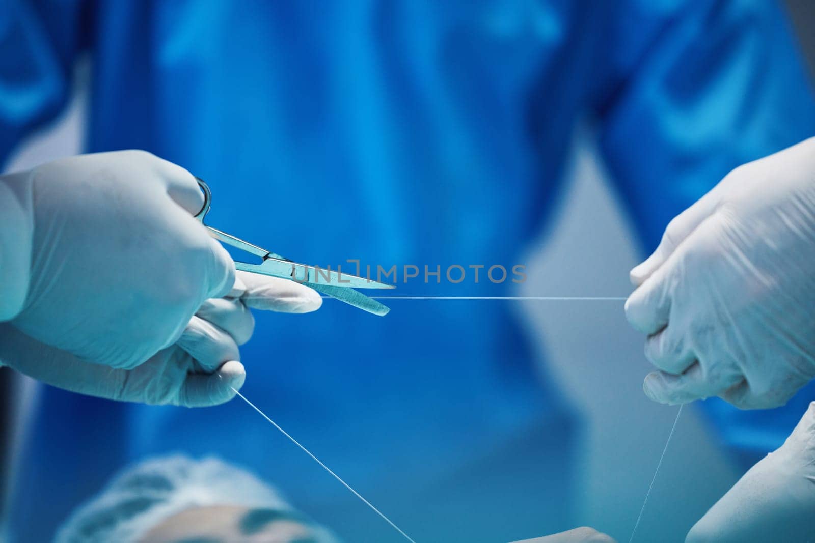 Surgery, hands and doctor cutting thread, stitching patient and surgical procedure with health insurance. People in medicine, surgeon with scissors and medical tools with collaboration in hospital.