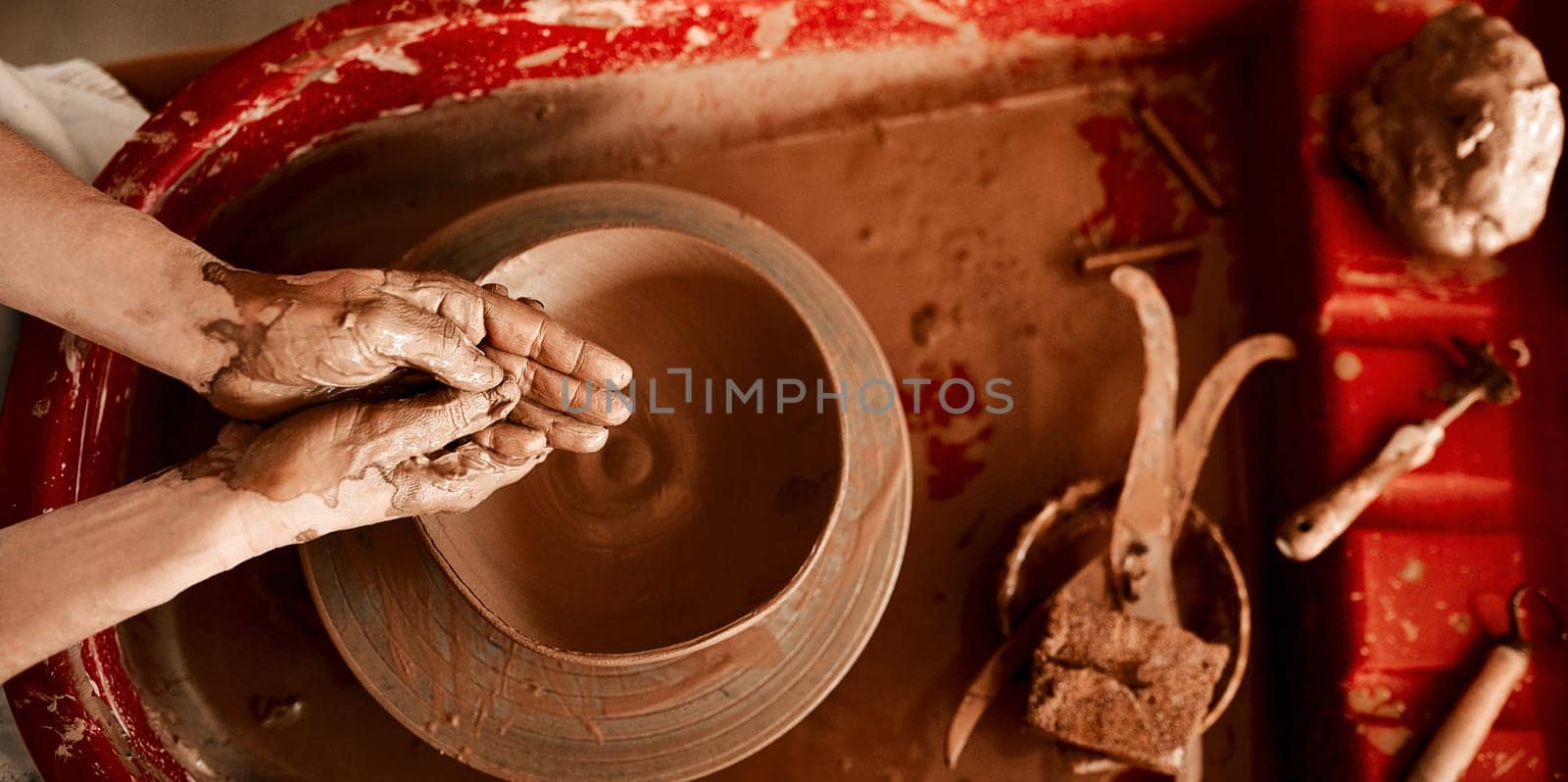 Getting my hands dirty is my favorite part. an unrecognizable woman molding clay on a pottery wheel. by YuriArcurs