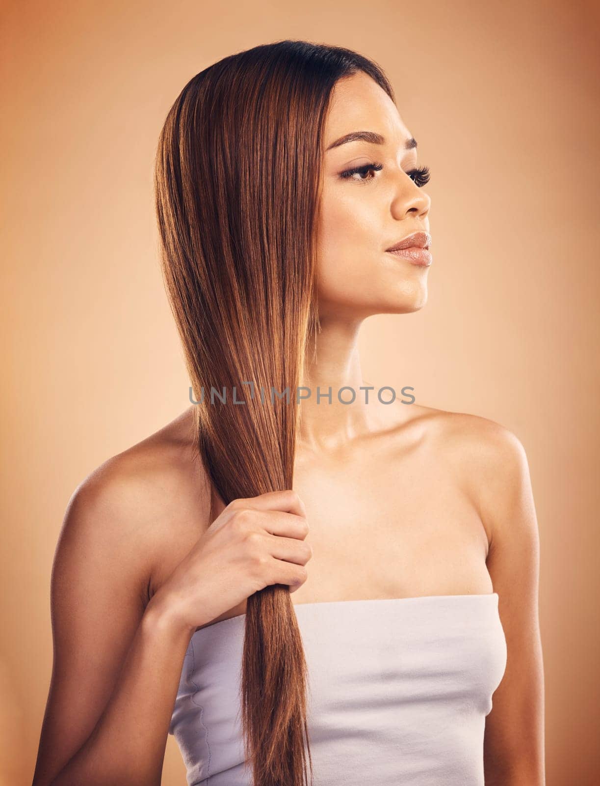 Woman, hair and beauty with salon hairstyle, haircare and keratin treatment isolated on brown studio background. Female model with highlights, color and cosmetic care, texture and growth with shine by YuriArcurs