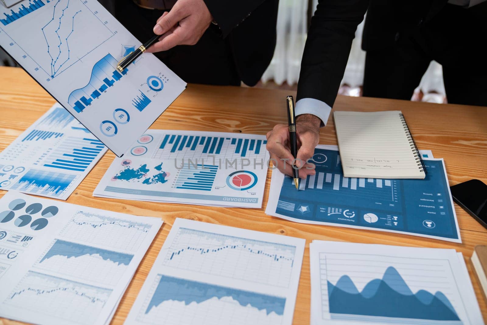 Closeup busy analyst team discussing financial data on digital dashboard, analyzing chart and graph using data science software display on a laptop screen. Business intelligence and Fintech. Fervent