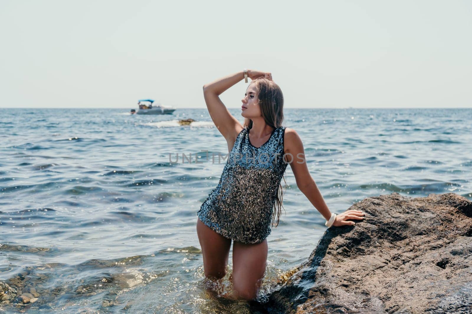 Woman summer travel sea. Happy tourist enjoy taking picture outdoors for memories. Woman traveler posing on the beach at sea surrounded by volcanic mountains, sharing travel adventure journey by panophotograph